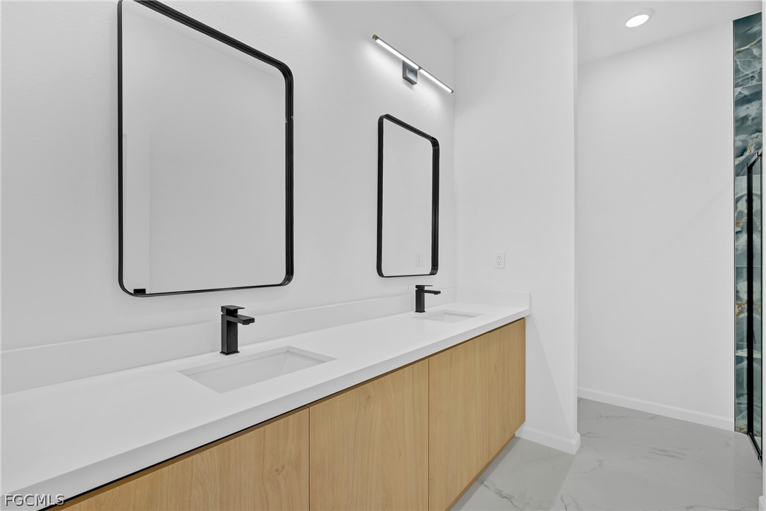5231 6th Street West Lehigh Acres, FL 33971 - Photo 22 of 26 a bathroom with a double vanity sink and mirror
