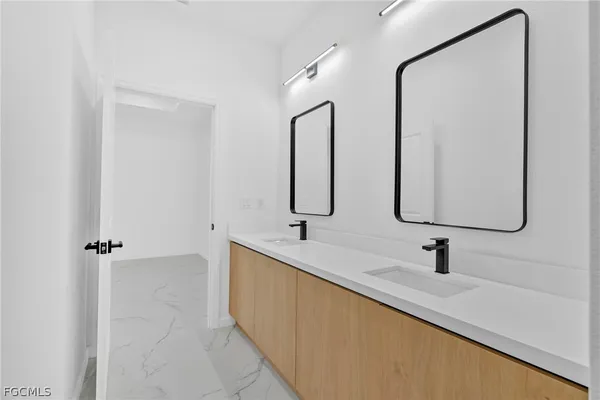 a bathroom with double vanity sink and a mirror