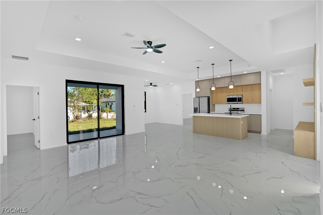 5231 6th Street West Lehigh Acres, FL 33971 - Photo 6 of 26 a view of a kitchen with furniture and a ceiling fan