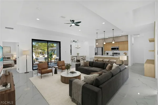 a living room with furniture kitchen view and a large window