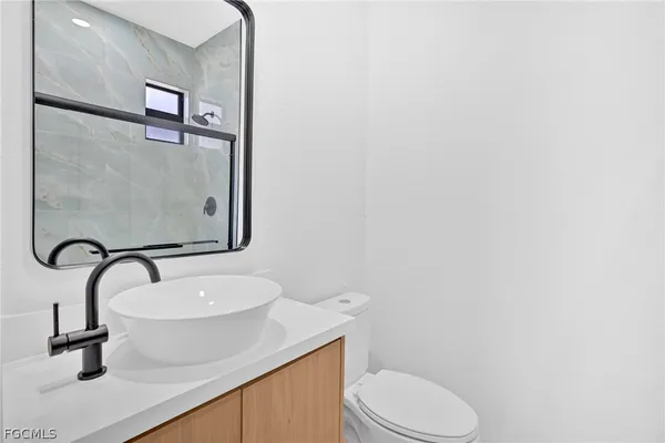 a bathroom with a sink a toilet and a mirror
