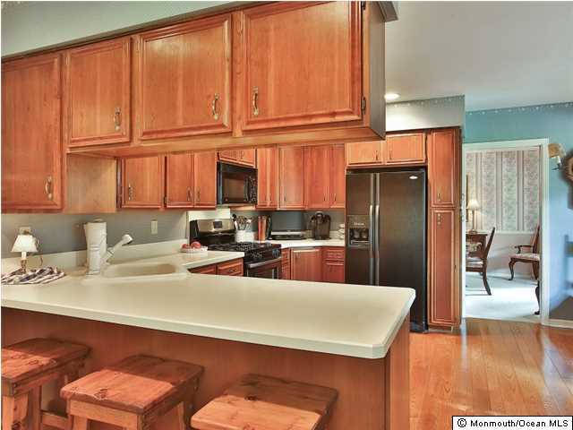 32 Woodhollow Road Colts Neck, NJ 07722 - Photo 7 of 23 a kitchen with stainless steel appliances granite countertop a refrigerator a sink a stove and white cabinets