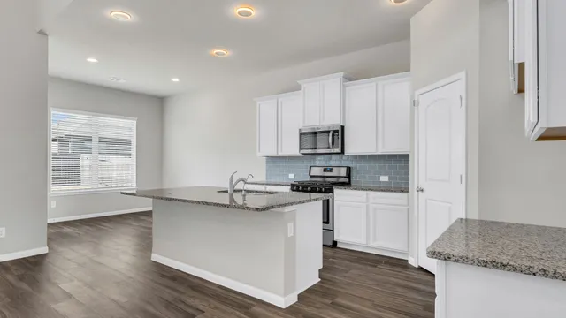 a kitchen with stainless steel appliances granite countertop a sink stove and cabinets