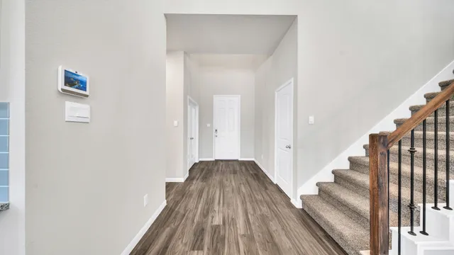 a view of a hallway with wooden floor and entryway