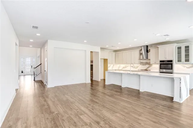 a large kitchen with kitchen island a large window a sink and stainless steel appliances