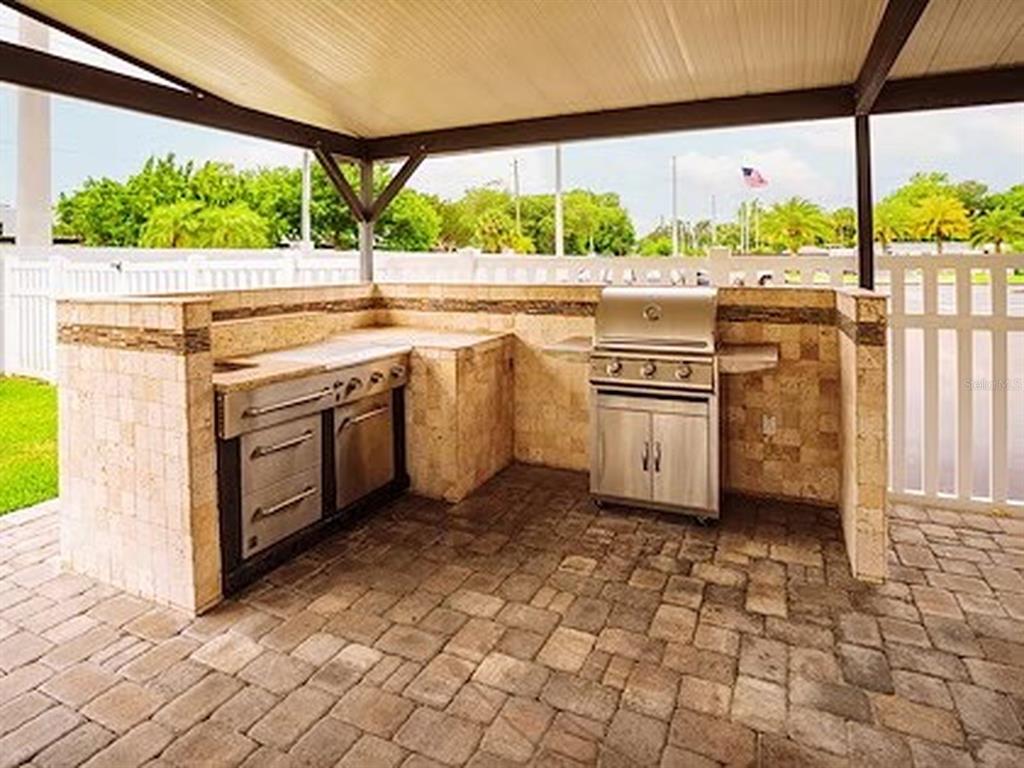 1000 Walker Street, Unit 160 Daytona Beach, FL 32117 - Photo 27 of 34 a kitchen with stainless steel appliances granite countertop a stove a sink and a microwave