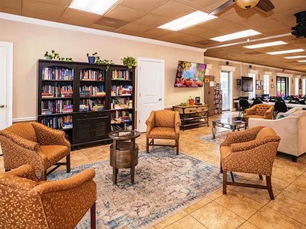 1000 Walker Street, Unit 160 Daytona Beach, FL 32117 - Photo 31 of 34 a living room with furniture a rug and a book shelf