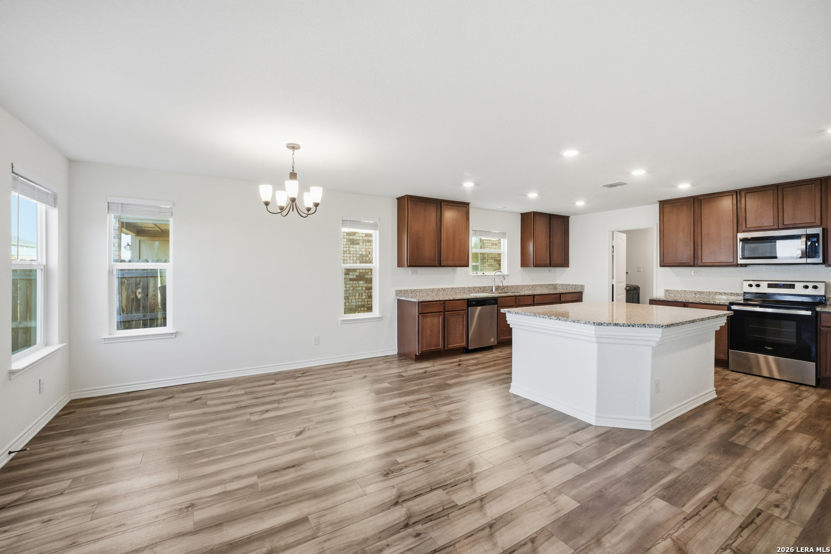 11331 Edelweiss San Antonio, TX 78245 - Photo 5 of 19 a large kitchen with a center island and wooden floor