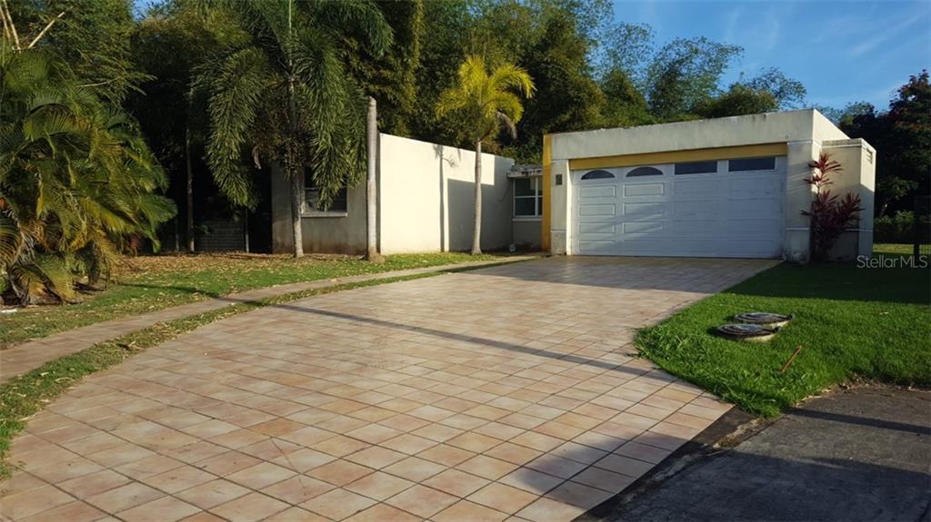 Rio La Plata Rio La, Unit 230 Caguas, PR 00725 - Photo 1 of 1 a front view of a house with a yard and a garage