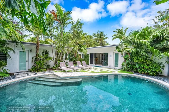 a view of a house with pool and sitting area