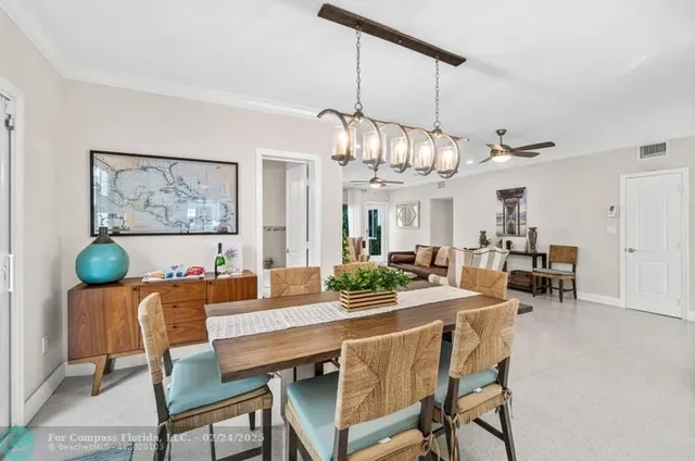 a dining room with furniture a chandelier and wooden floor