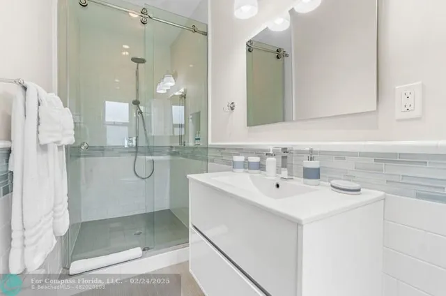 a bathroom with a shower a sink and a mirror