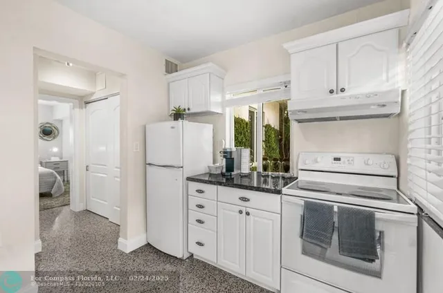 a kitchen with white cabinets and white appliances