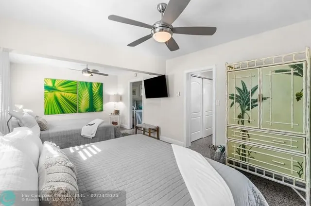 a bedroom with a bed a flat screen tv and a couch