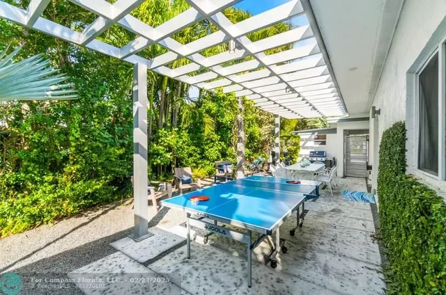a table and chairs in a patio with potted plants