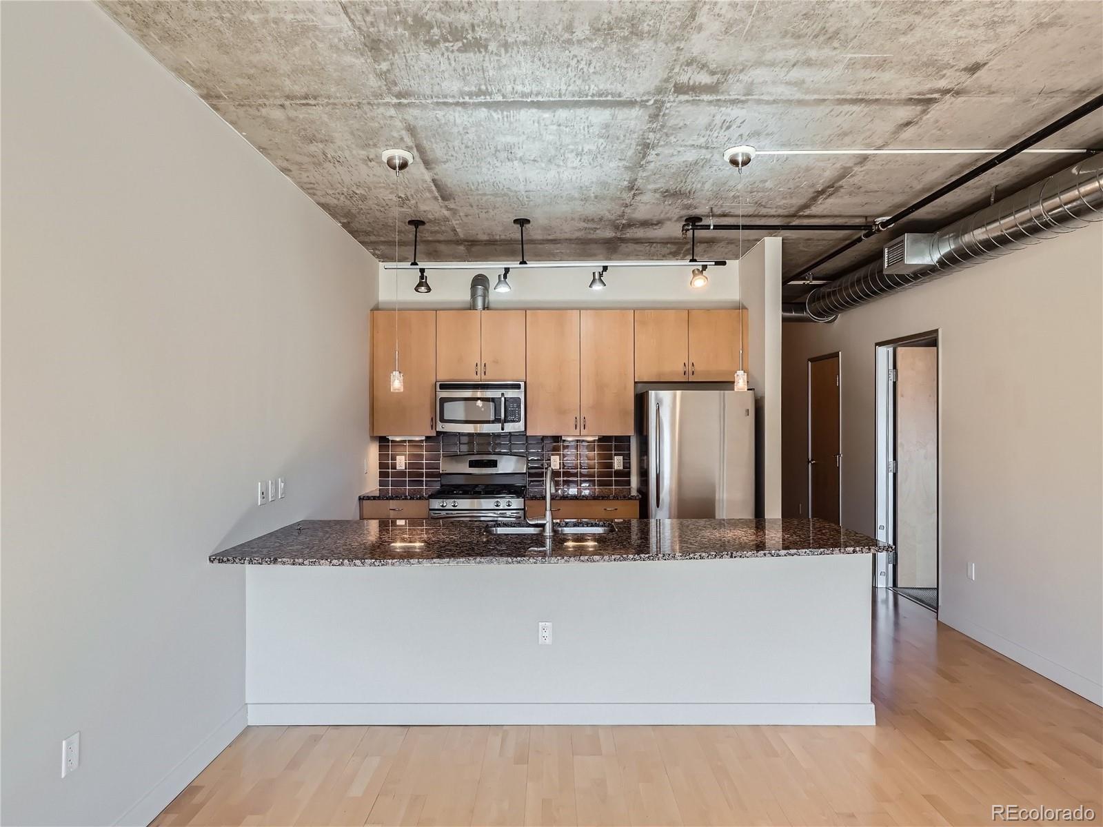 2229 Blake Street, Unit 406 Denver, CO 80205 - Photo 12 of 27 a view of kitchen with stainless steel appliances wooden floor