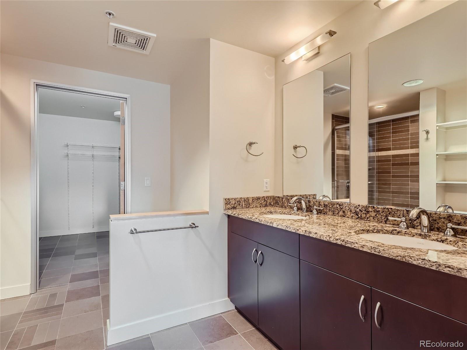 2229 Blake Street, Unit 406 Denver, CO 80205 - Photo 19 of 27 a bathroom with a granite countertop sink and a mirror