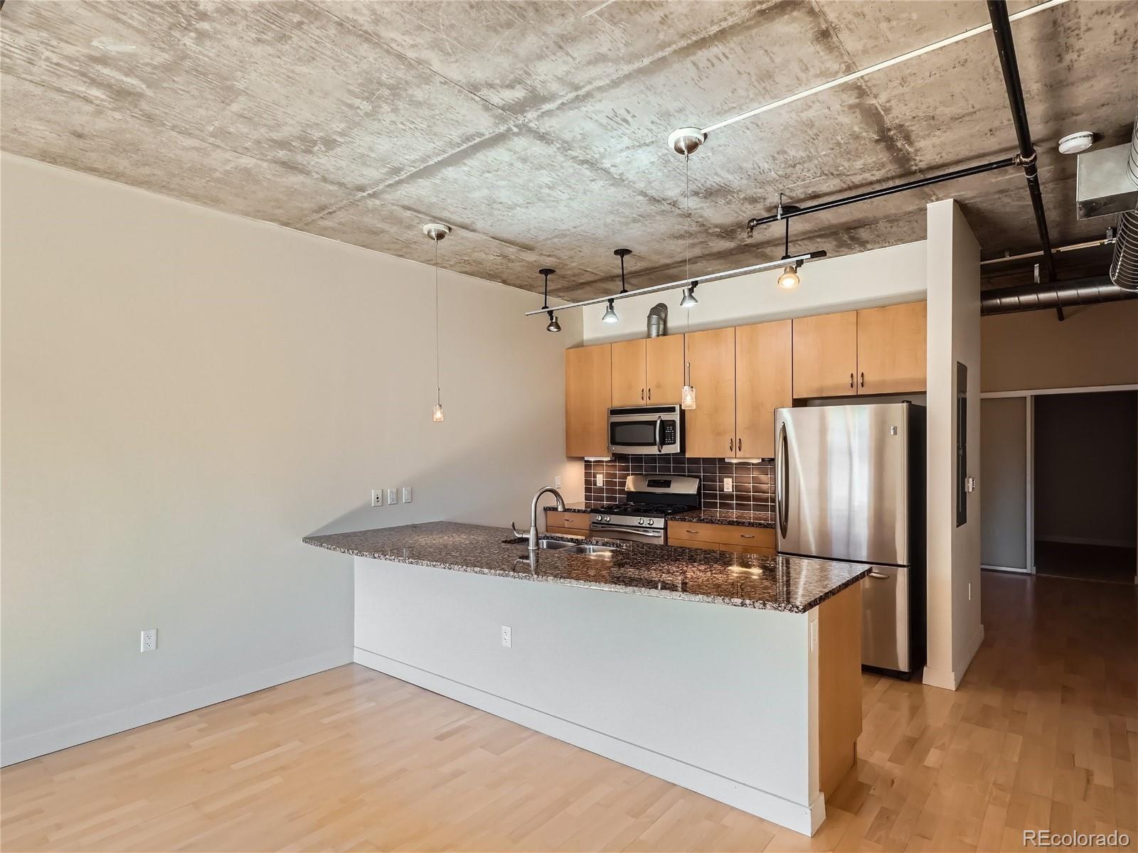 2229 Blake Street, Unit 406 Denver, CO 80205 - Photo 10 of 27 a kitchen with stainless steel appliances granite countertop a refrigerator and a stove