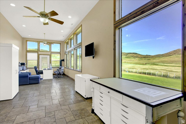 667 Hardscrabble Road Morgan, UT 84050 - Photo 22 of 51 Kitchen featuring stone tile floors, a ceiling fan, white cabinetry, a high ceiling, and pendant lighting