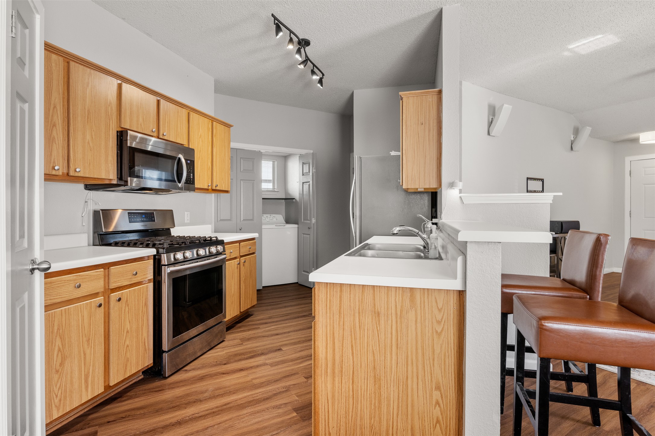 8120 Tockington Way Austin, TX 78748 - Photo 10 of 27 a kitchen with stainless steel appliances granite countertop a kitchen island hardwood floor sink stove dining table and chairs