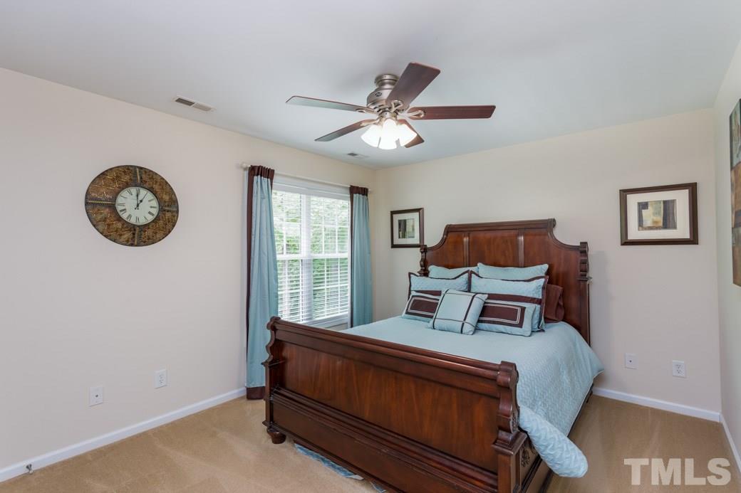 5206 Groveside Court Raleigh, NC 27613 - Photo 7 of 12 a bed sitting in a bedroom next to a window
