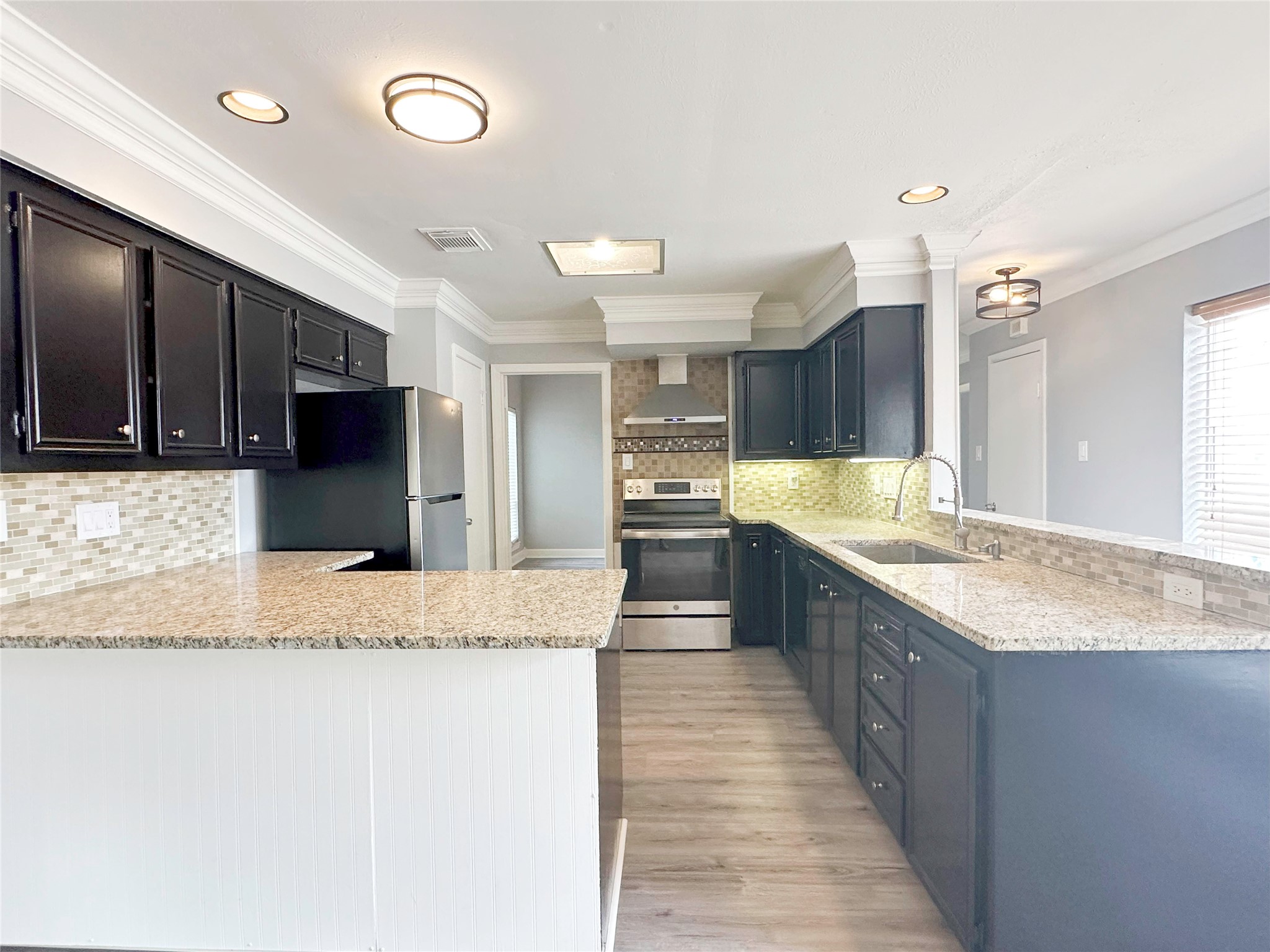 6806 Winkleman Road Houston, TX 77083 - Photo 14 of 29 a large kitchen with kitchen island a sink stainless steel appliances and cabinets