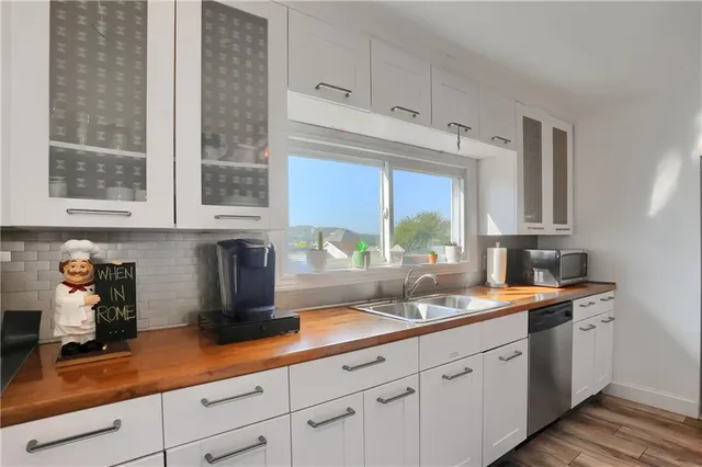 a kitchen with stainless steel appliances white cabinets and a window