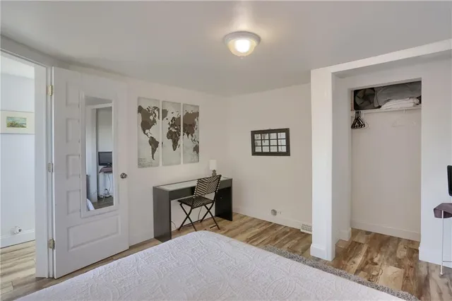 a bedroom with a bed and a painting on the wall