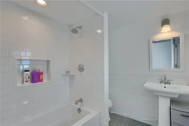 a bathroom with a sink shower and a mirror