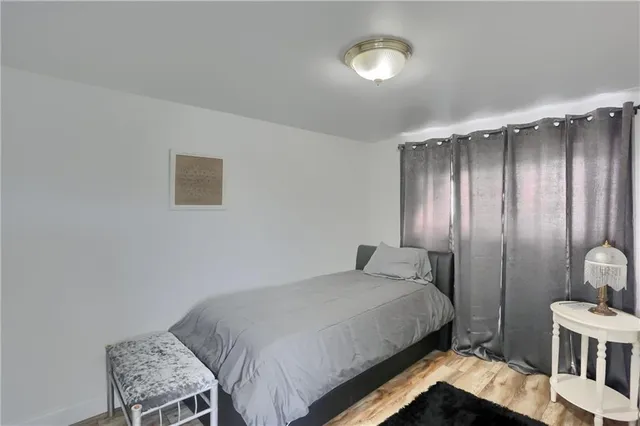 a bedroom with a bed window and chair