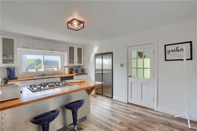 a view of kitchen with stainless steel appliances granite countertop a stove and a refrigerator
