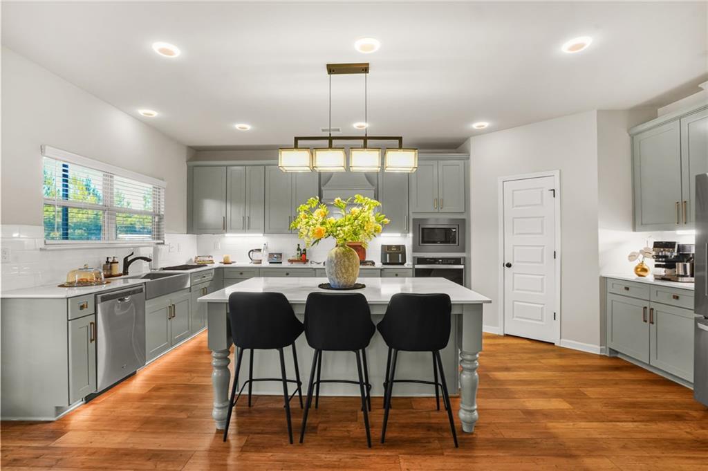 118 Arabella Pike Locust Grove, GA 30248 - Photo 11 of 39 a kitchen with stainless steel appliances granite countertop a table chairs sink refrigerator and microwave