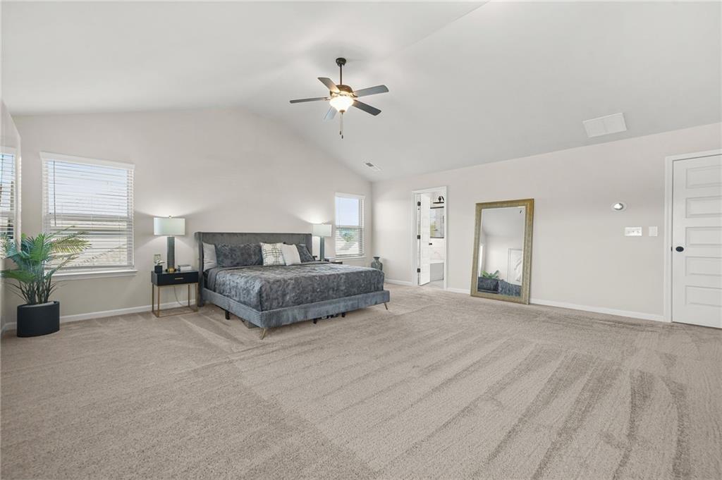 118 Arabella Pike Locust Grove, GA 30248 - Photo 23 of 39 a spacious bedroom with a bed and a chandelier