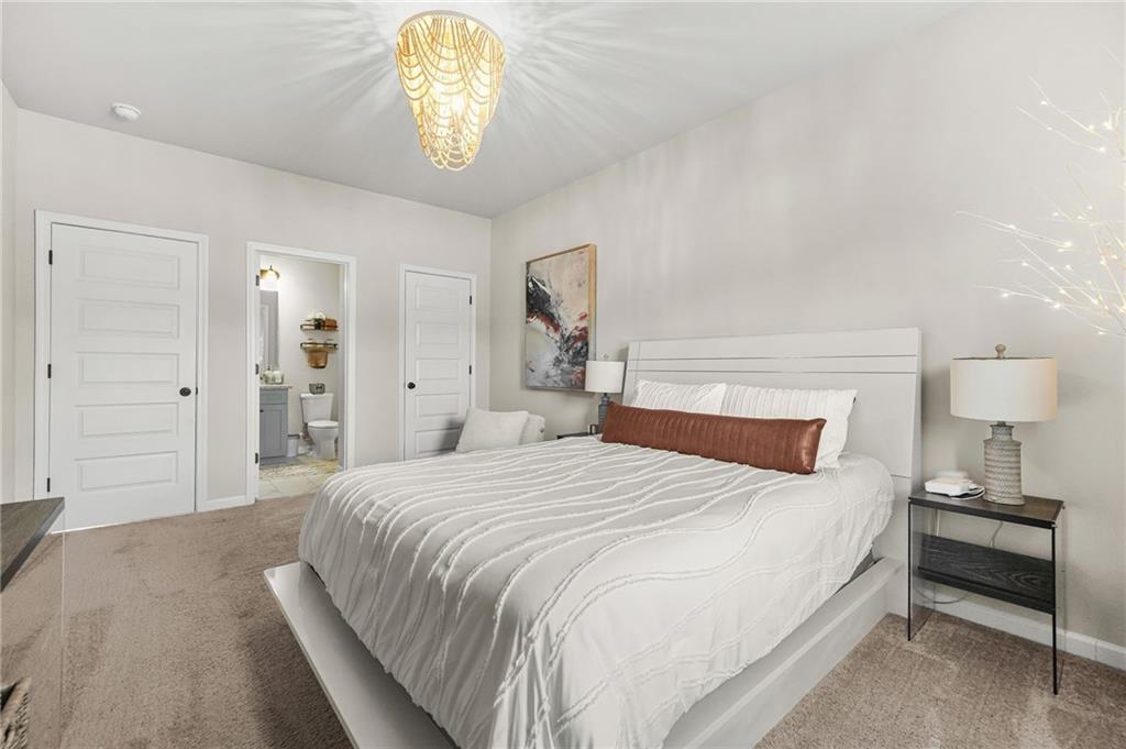 118 Arabella Pike Locust Grove, GA 30248 - Photo 29 of 39 a bedroom with a bed and a chandelier