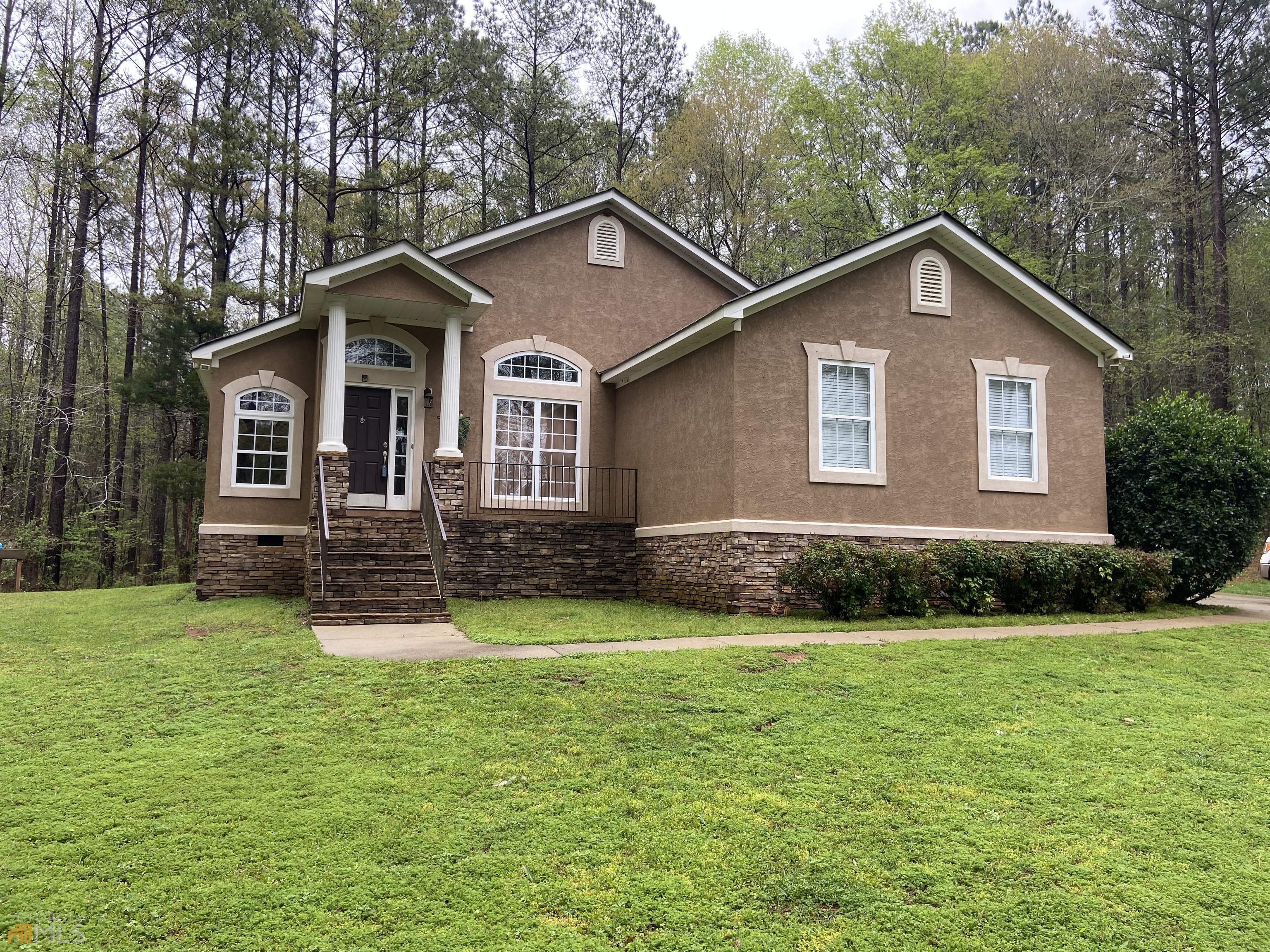 a front view of a house with yard and green space