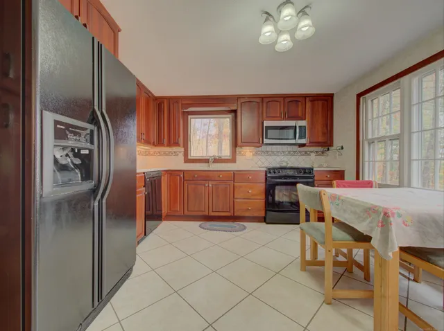 a kitchen with stainless steel appliances granite countertop a refrigerator and a stove top oven
