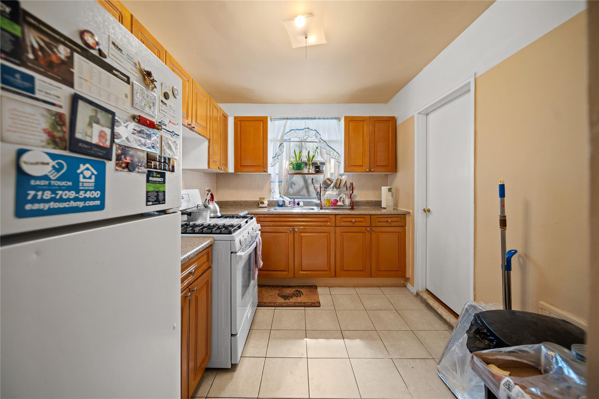 1199 East 53rd Street, Unit 1D Brooklyn, NY 11234 - Photo 4 of 10 a kitchen with a sink a stove cabinets and a window