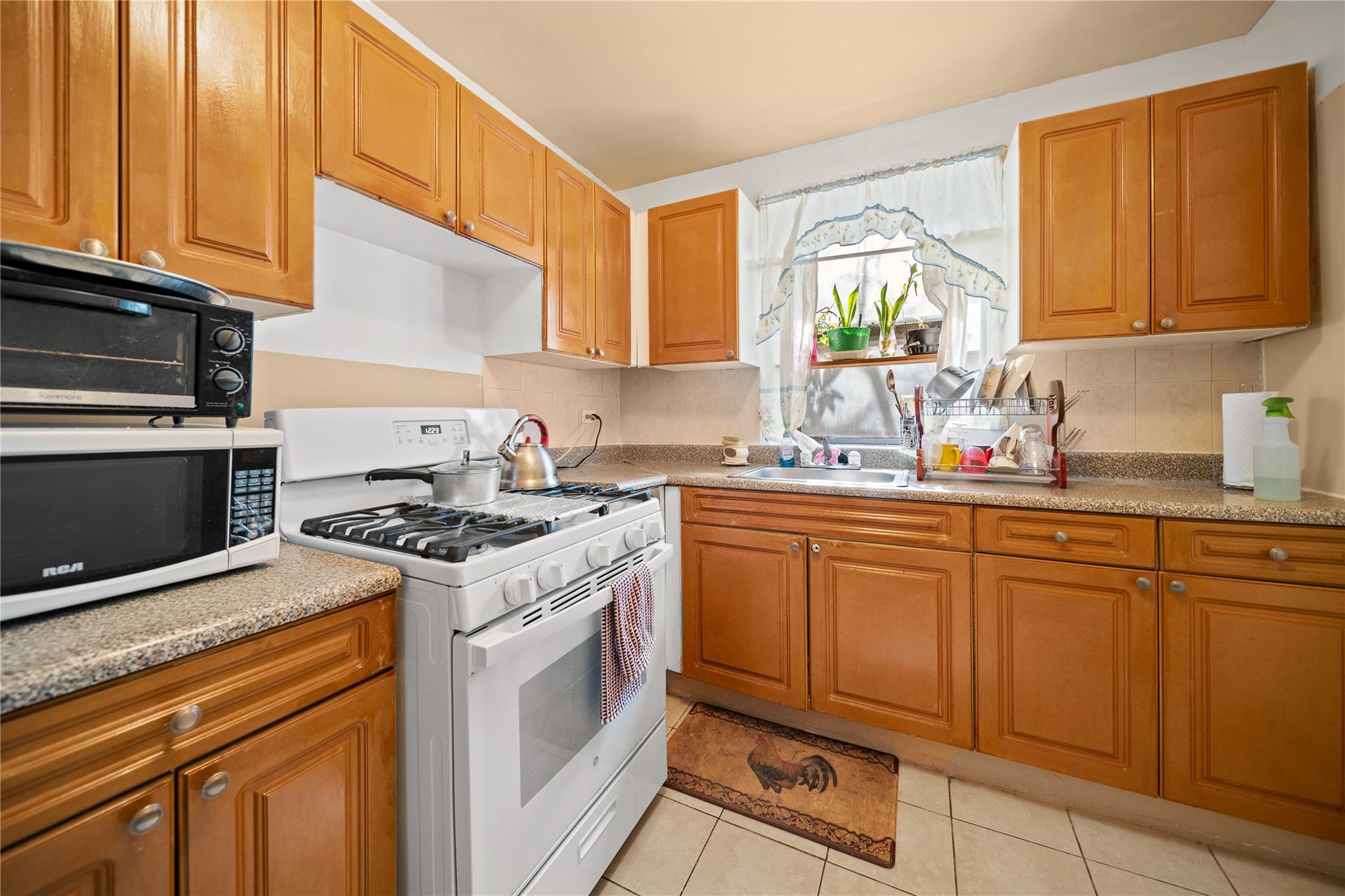 1199 East 53rd Street, Unit 1D Brooklyn, NY 11234 - Photo 5 of 10 a kitchen with granite countertop a sink stainless steel appliances and cabinets