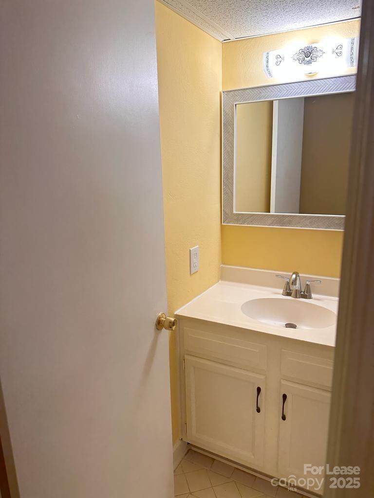 5808 Hunting Ridge Lane, Unit A Charlotte, NC 28212 - Photo 11 of 18 a bathroom with a sink and a mirror