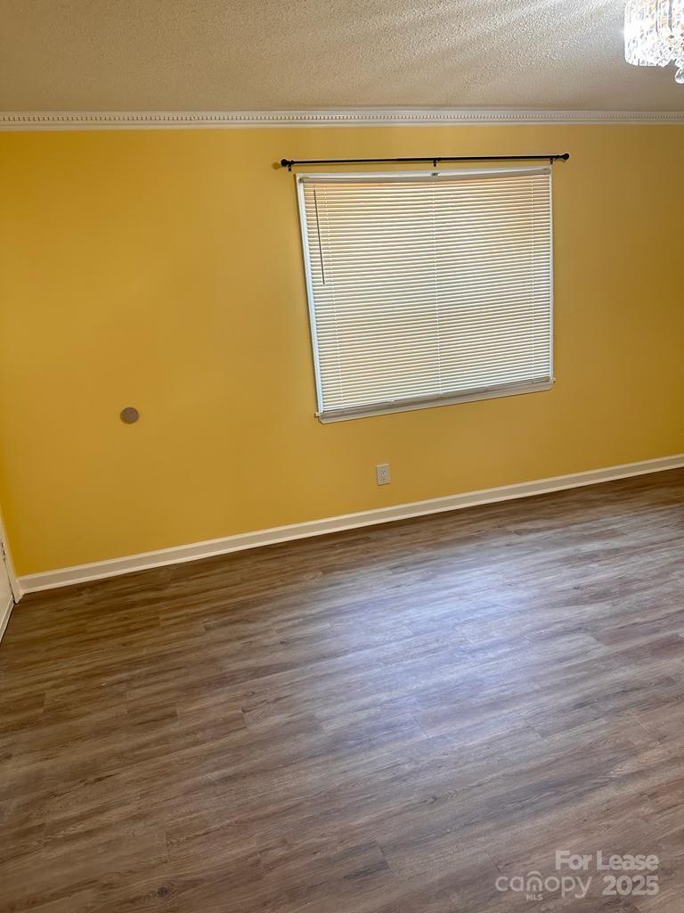 5808 Hunting Ridge Lane, Unit A Charlotte, NC 28212 - Photo 12 of 18 a view of an empty room with wooden floor and a window