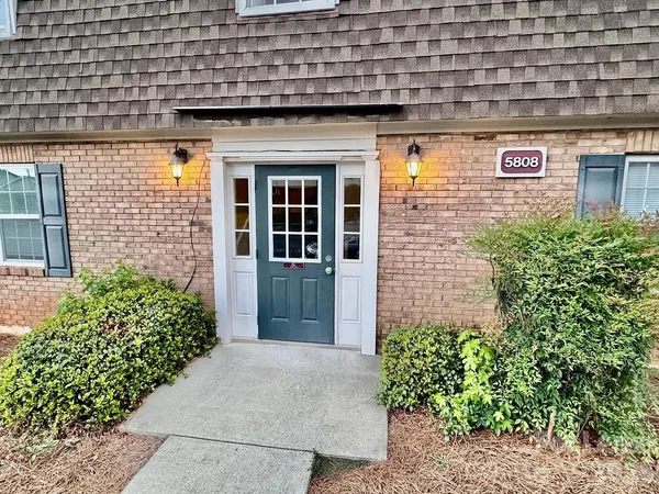 a view of a brick house with plants