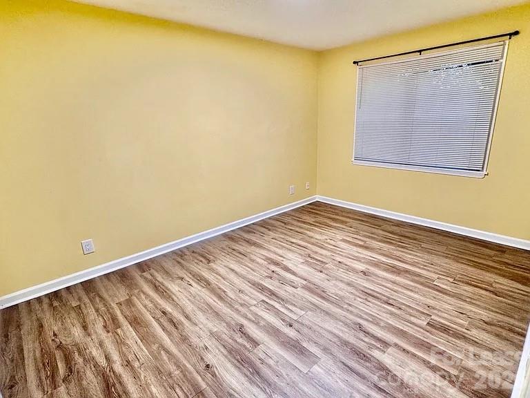 5808 Hunting Ridge Lane, Unit A Charlotte, NC 28212 - Photo 6 of 7 a view of an empty room with wooden floor and a window