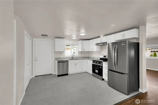 a kitchen with a refrigerator sink and stainless steel appliances