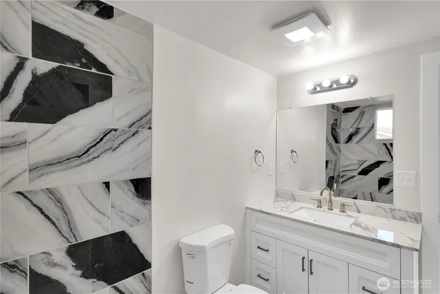 a bathroom with a sink a toilet and a mirror