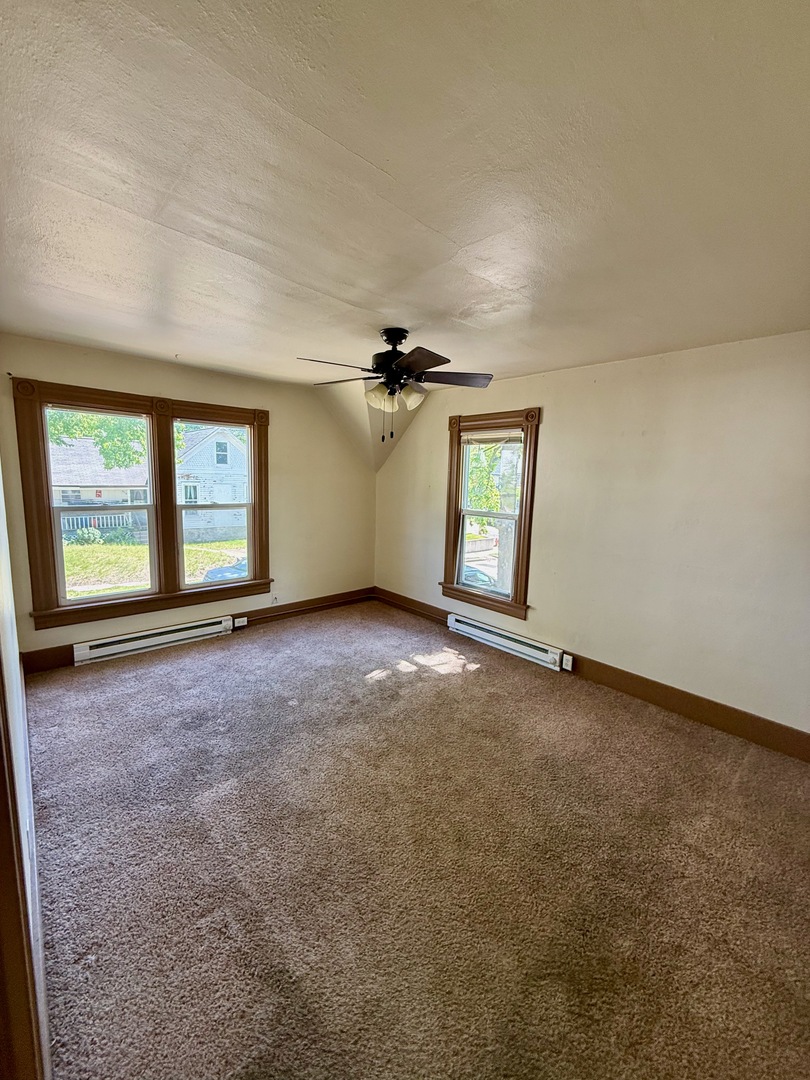 913 West 4th Street Dixon, IL 61021 - Photo 3 of 8 an empty room with windows and ceiling fan