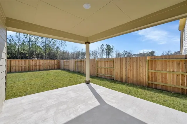 a view of a backyard with wooden fence