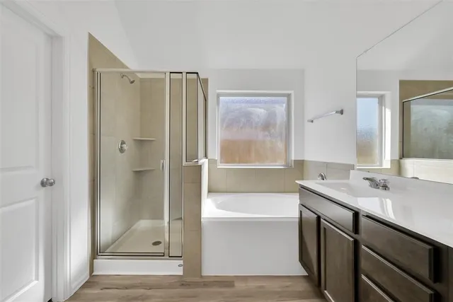 a bathroom with a tub sink shower and mirror