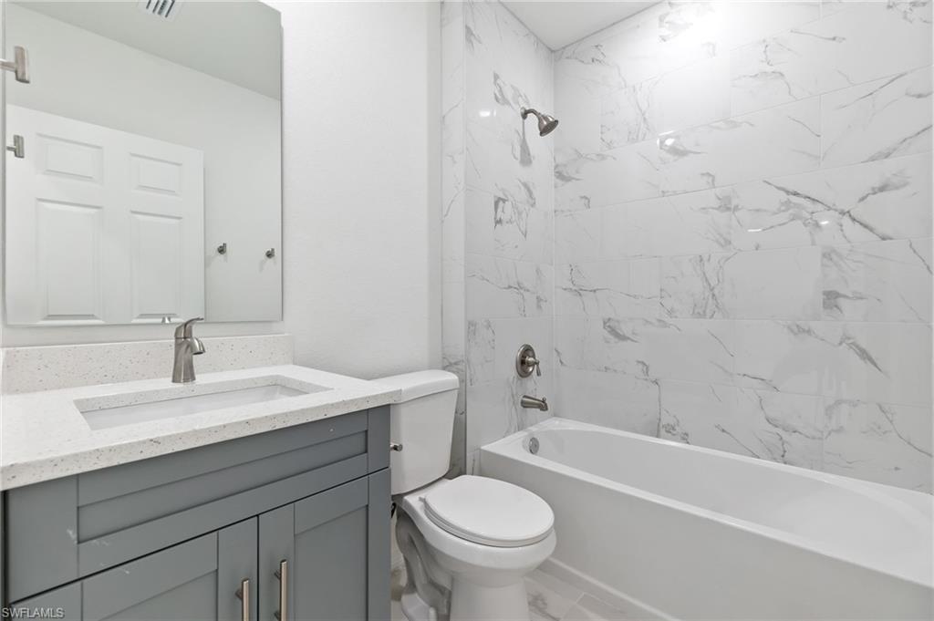 3707 Sunset Road Lehigh Acres, FL 33971 - Photo 13 of 16 a bathroom with a sink a toilet and a bathtub