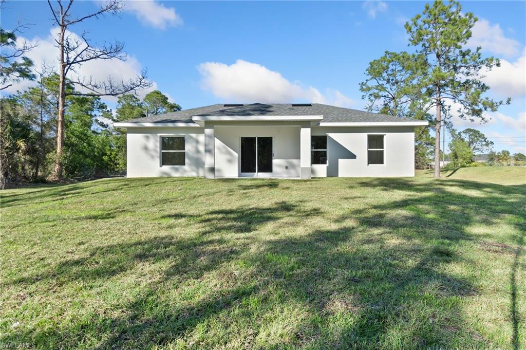 3707 Sunset Road Lehigh Acres, FL 33971 - Photo 15 of 16 a front view of house with yard and trees in the background