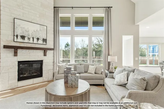a living room with furniture a fireplace and a large window